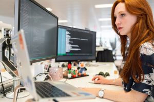 Woman works at her desk inside an open concept office.