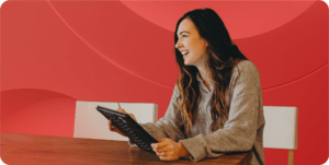 Devops engineer sits at a table smiling and looking to someone off camera.